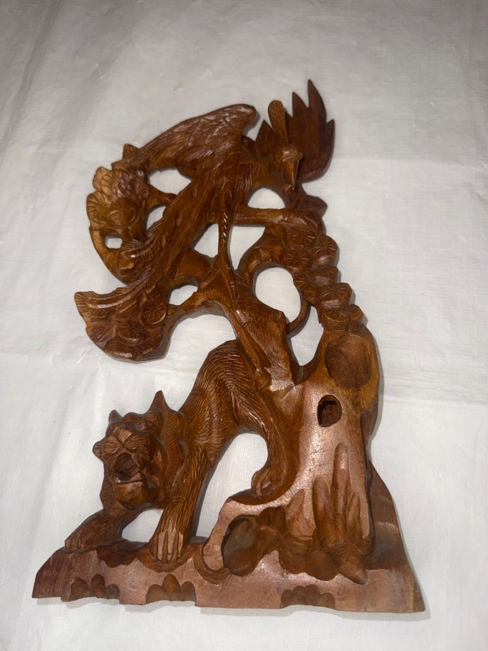 handcrafted wooden carving featuring a stylized eagle or phoenix perched above a